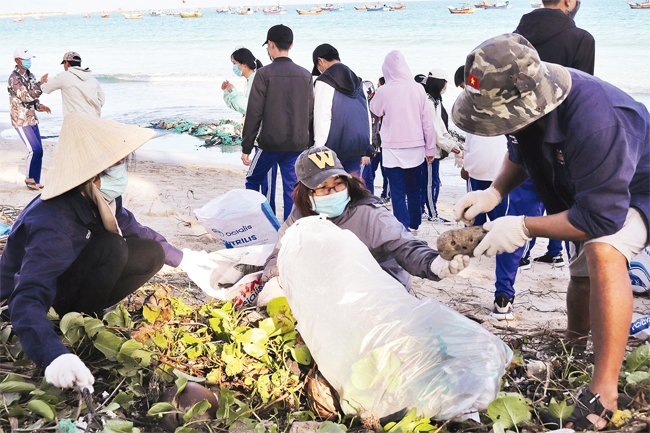 A group of volunteers pick up trash at the beach in Ninh Hoa town
